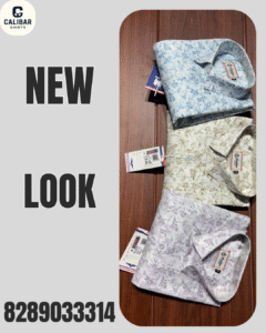 Three folded men’s printed shirts in pastel shades (blue, beige, and lavender) with tags attached, displayed on a wooden surface.