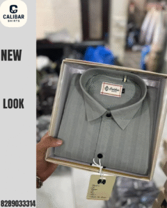 A person holding a neatly packed grey formal shirt from Calibar Shirts, displayed in a premium box with a tag attached.