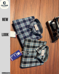 A miniature, vintage-style black and gold Singer sewing machine is placed to the right of the shirts.