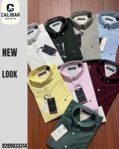 A set of premium plain shirts in various colors — white, green, grey, blue, yellow, pink, maroon, and dark green — neatly arranged on a wooden surface.