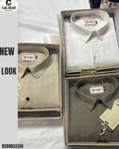 Three neatly folded shirts in beige, white, and olive shades displayed in boxes, representing a premium linen shirt collection.