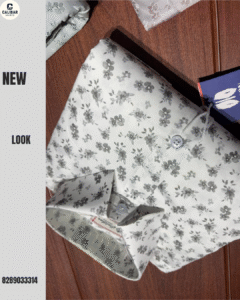 Folded white floral printed shirt placed on a wooden surface, showcasing a fresh and stylish design.